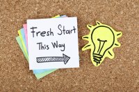 Bulletin board with sticky note that reads "Fresh start this way"