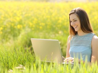 Young woman working outside on laptop